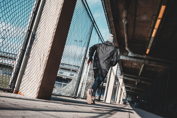 Male runner preparing to city marathon in gateway stadium. Man athlete running through urban view