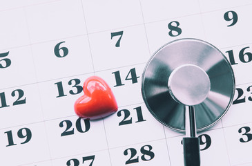 Calendar organizer day marked with red 3d heart and stethoscope with flat lay view, doctor`s appointment or heart health concept. Healthcare system.
