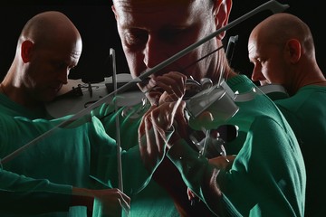 portrait of a violinist in the studio in a low key, male 50s, master of violin playing,...