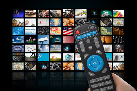 TV set with lot of pictures and hands of man with remote control.