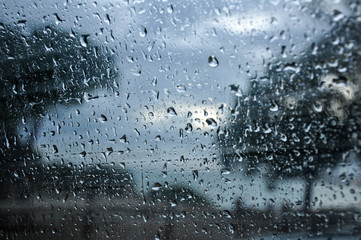 Fototapeta na wymiar Raindrops on a window with a landscape
