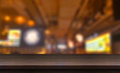 Wood table top and blurred background food of restaurant.