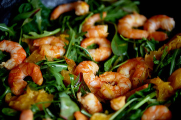 Healthy diet. Salad of arugula, tiger prawns and oranges. Light dish with seafood. Diet menu.