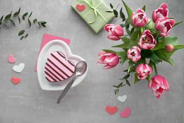 Pink heart ice cream on ceramic plate and bunch of pink tulips