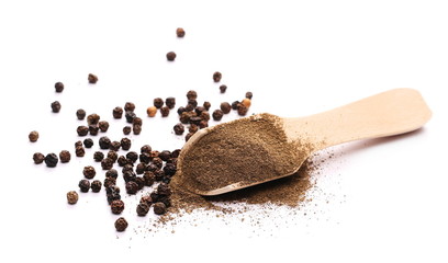 Black pepper grains and powder with wooden spoon isolated on white background