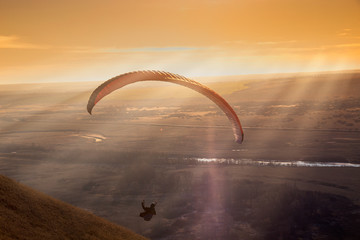 Paraglider during the flight in the sunlight