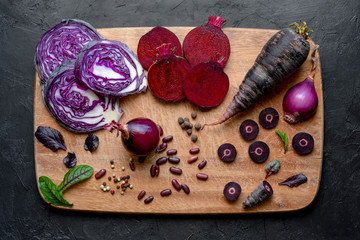 Sliced purple vegetables on a wooden cutting board. Top view