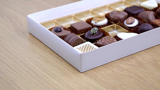 hand picking fine gourmet chocolates from a gift box