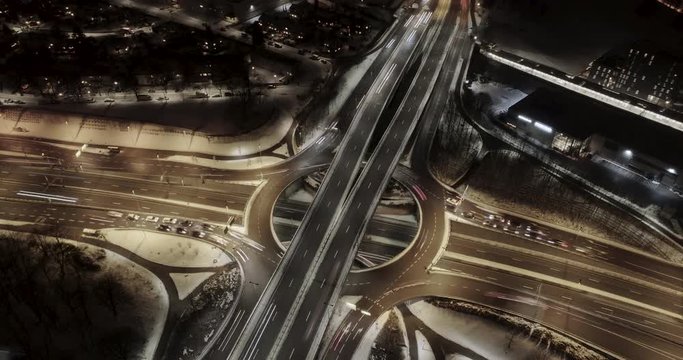 4K high angle aerial view hyperlapse of night traffic on busy freeway with 4 way intersection and circle roundabout in Oslo city, Norway.