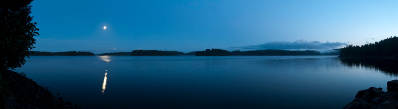 Seepanorama mit Mondspiegelung - wolkenloser Himmel am windstillen Abend in unber&uuml;hrter Natur	