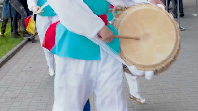 Korean national festival. A group of musicians and dancers in bright colored suits perform traditional Korean folk dance Samul nori Samullori or Pungmul and play percussion Korean musical instruments