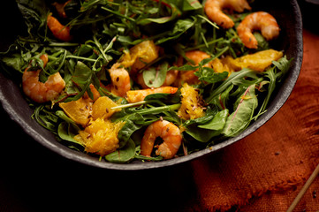 Healthy diet. Salad of arugula, tiger prawns and oranges. Light dish with seafood. Diet menu.