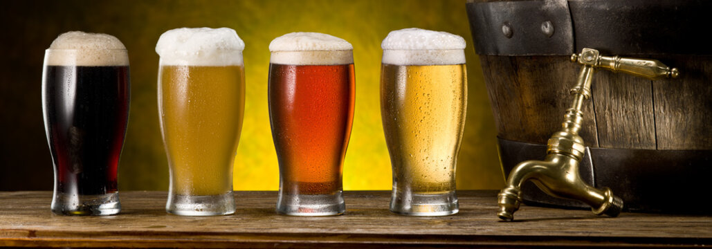 Glasses Of Beer And Beer Cask On The Wooden Table. Craft Brewery.