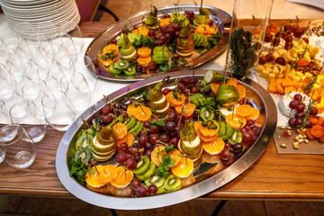 Plate with fruits and berries on table, event catering. © 9parusnikov