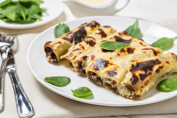 Cannelloni with minced beef and spinach baked in béchamel sauce. 