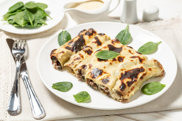Cannelloni with minced beef and spinach baked in béchamel sauce. 