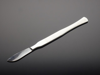 Dental medical knife on gray gradient background