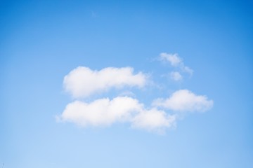 Fluffy white clouds on the clear blue sky background.