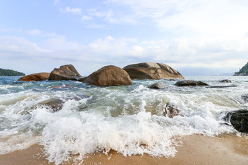 rompiente de olas en la playa entre rocas