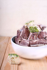 Halva and sherbet in a bowl against the wooden background. Assortment of oriental desserts
