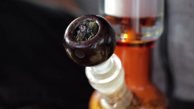 Closeup of a person smoking marijuana/cannabis in a bong.