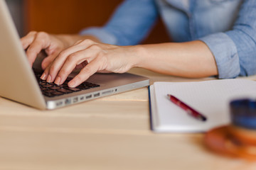 Female hands typing on laptop keyboard. Close up