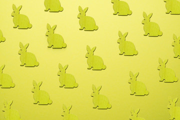 Wooden Easter Bunnies as attribute of Easter celebration. Yellow background.