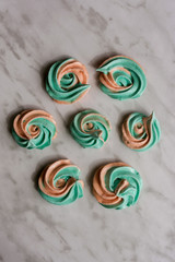 rainbow meringue kisses, soft peach and mint colors on marble background