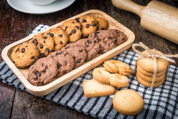 Chocolate chip cookies Closeup with cup and rolling pin on wooden tabel.