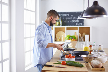 Smiling and confident chef standing in large kitchen