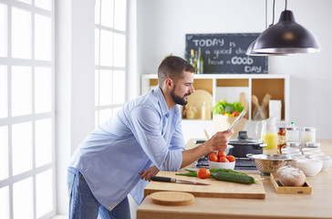 Smiling and confident chef standing in large kitchen