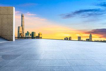 Empty square floor and modern city buildings in Shanghai at dusk