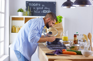 Smiling and confident chef standing in large kitchen
