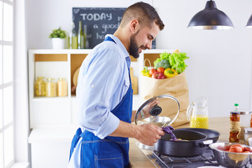 Smiling and confident chef standing in large kitchen