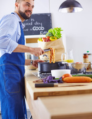 Smiling and confident chef standing in large kitchen