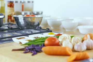 Composition with wooden board and ingredients for cooking on table