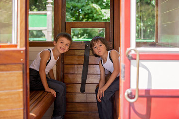 Beautiful children, dressed in vintage clothes, enjoying old steam train on a hot summer day