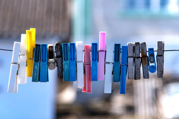 Colorful clothespin hanging on a rope. Plastic and wooden clothespins