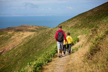 Father and sons, hiking in a beautiful nature of North Devon on a sunny day