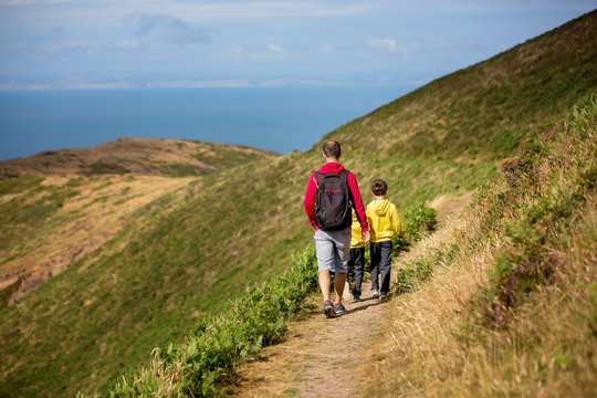 Father and sons, hiking in a beautiful nature of North Devon on a sunny day