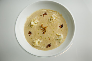 beige seafood cream soup decorated with dried squid and soy sauce