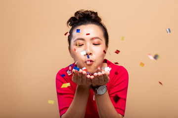 Naklejka premium Portrait of a cheerful woman with confetti rain and celebrating isolated over background
