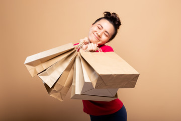 Portrait of woman holding shopping bags isolated over background