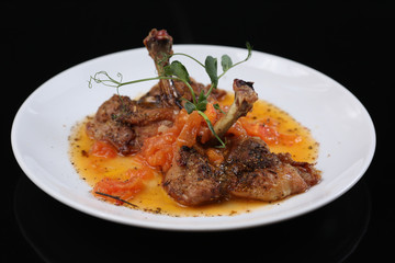fried chicken leg with tomatoes and spices on a plate