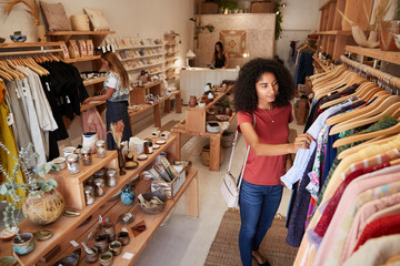 Customers Browsing In Independent Clothing And Gift Store