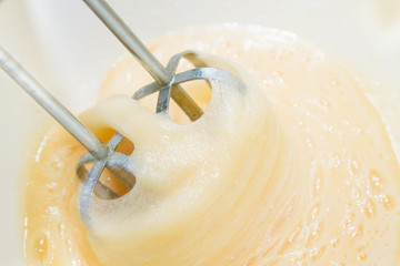 Sugar is mixed with beaten egg for dessert