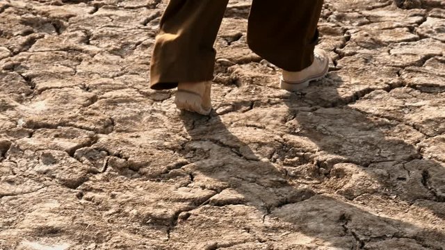 Woman walking over dry soil