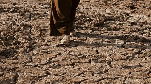 Woman walking over dry soil