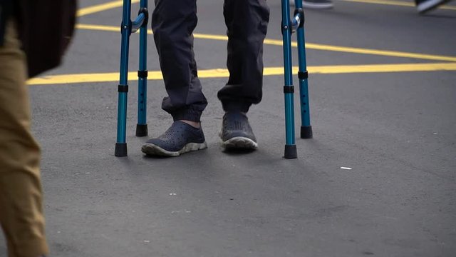 old man crossing road using a walker