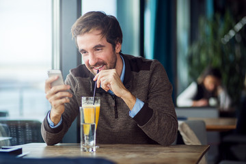 Cheerful businessman using his smartphone